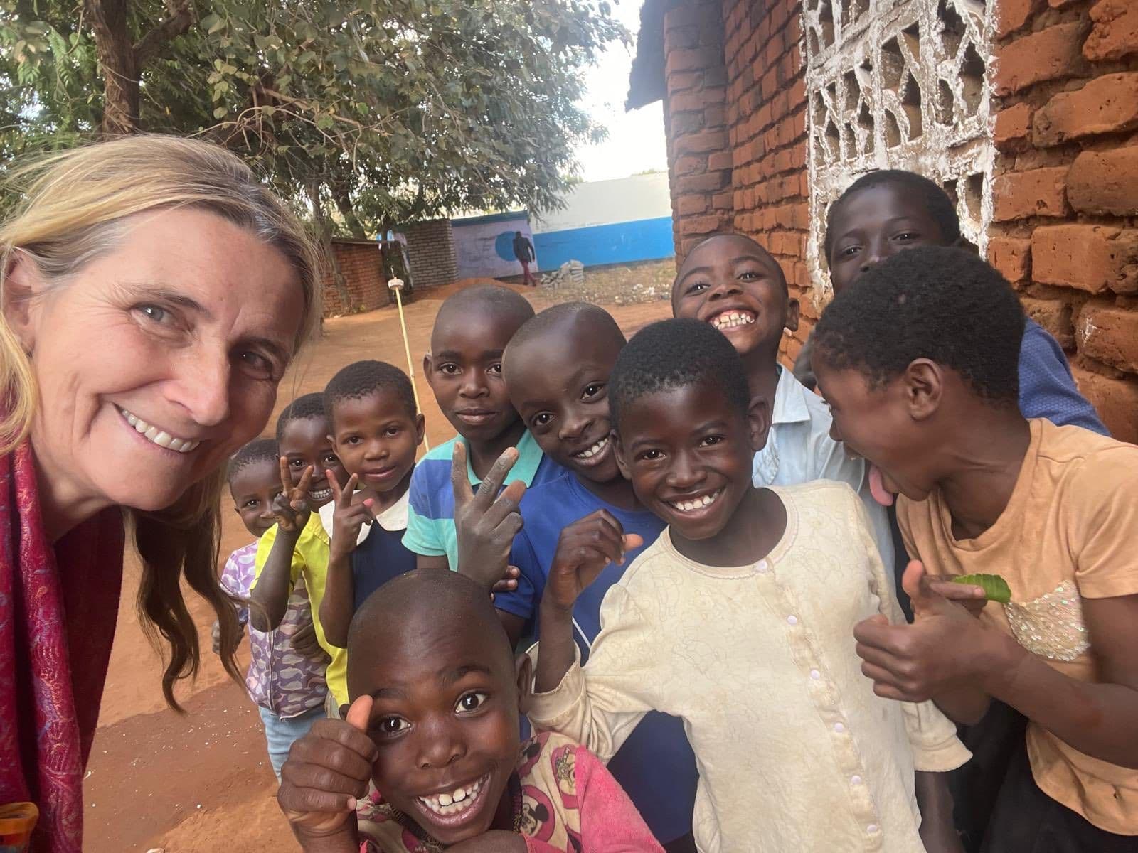 Mandy surrounded by smiling children in Africa